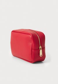 Red synthetic cosmetic bag with a rectangular shape, smooth texture, gold zipper, and a small brand tag. Elegant and compact design.