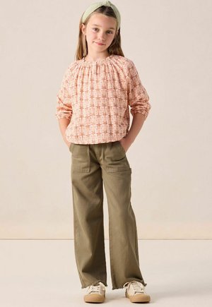 Floral-patterned, light pink blouse with gathered neckline; paired with loose olive green cargo pants and beige sneakers. Light headband accessory.