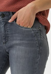 Jeans in denim grigio con design a cinque tasche, caratterizzati da una vita alta e un leggero effetto sbiadito. Il tessuto è morbido e con una leggera elasticità.