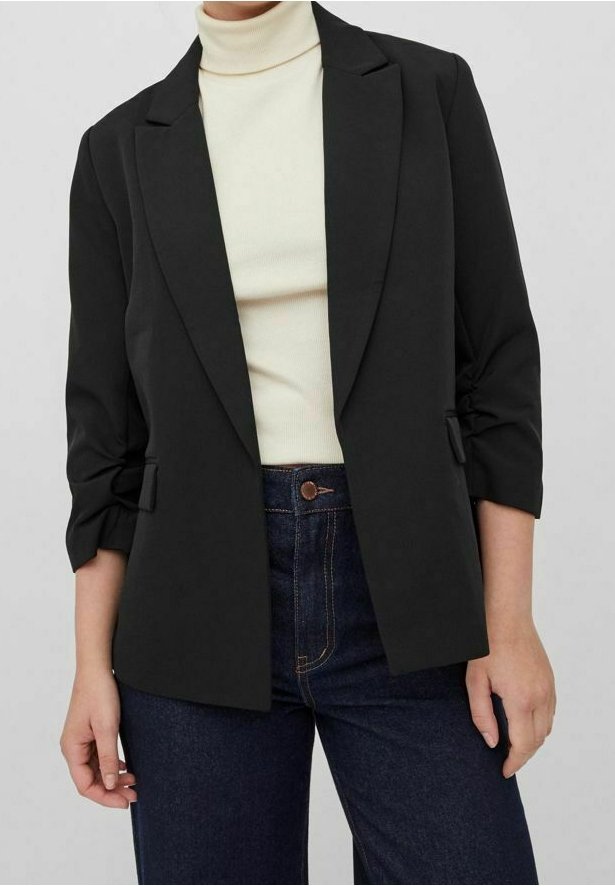 Černý blejzr s upraveným střihem, zapínání na jeden knoflík a s ohrnutými rukávy. Nosit přes smetanový rolák a v kombinaci s džíny s vysokým pasem.