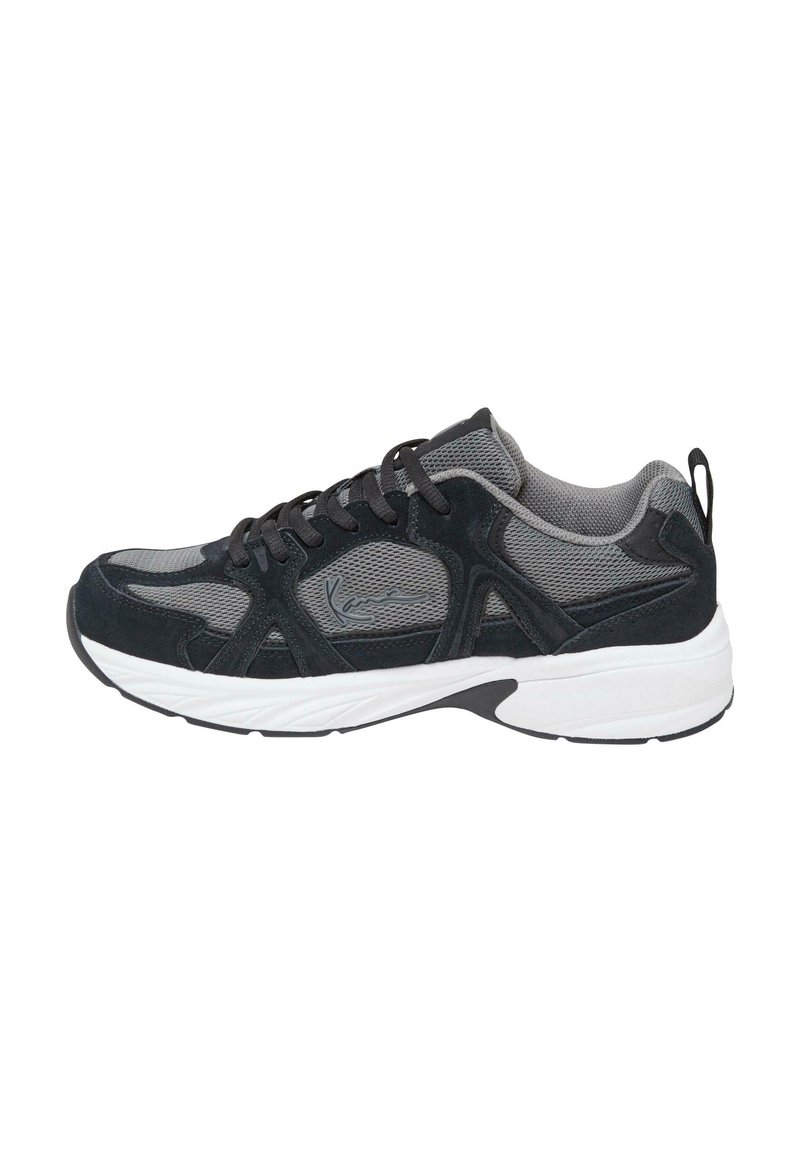 Baskets de sport gris et noir avec tissu en mesh, surpiqûres en daim, lacets noirs et semelle blanche épaisse, vues de profil droit.