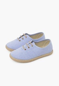 Scarpe in tela blu chiaro con punta rotonda, suole in iuta e tre lacci beige attraverso occhielli dorati. Texture liscia con design minimal.