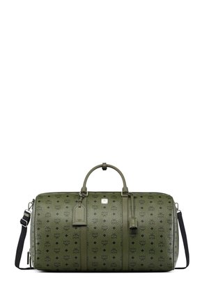 Olivengrøn duffelbag med MCM-logo print, korte håndtag, sort skulderrem, bagagemærke og fastgjort nøglering, på hvid baggrund.