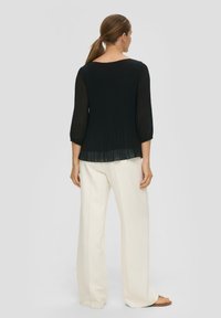 Must have pleedi top, millel on läbipaistvad pikad varrukad, ühendatud valgete laia säärega pükstega ja mugavate sandaalidega. Minimalistlik ja elegantne disain.