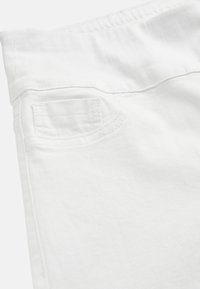 Zbliżenie na pas białych dżinsów z denimu i małą przednią kieszonkę z widocznymi detalami szwów.