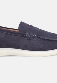 Navy-Suede Slipper mit runder Zehenpartie, weißer Sohle und kontrastierenden Nähdetails im Obermaterial. Glatte Textur mit subtiler Glanz.
