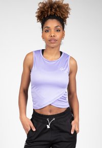 Lavender mouwloze cropped top met een wikkelontwerp, gemaakt van een gladde stof. Bevat een wit logo op de linkerborst, gecombineerd met zwarte joggers.