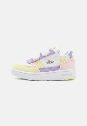 Witte sneaker met pastelgele, roze en paarse accenten, twee klittenbandsluitingen en een Lacoste-logo aan de zijkant.