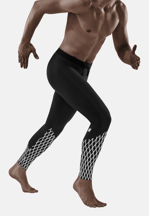 Schwarze Sport-Leggings mit einem weißen Design im Diamantmuster am Unterschenkel, ausgestattet mit einem Kordelzugbund und einer taillierten Silhouette.