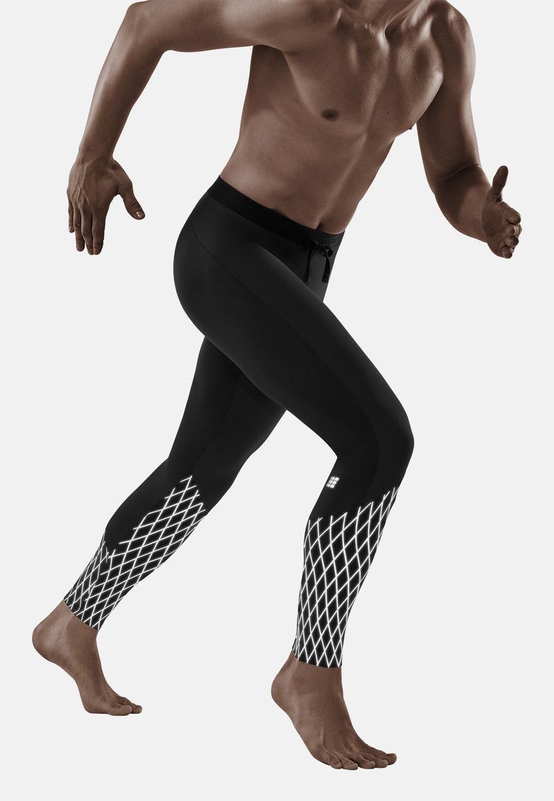 Zwarte sportlegging met een wit diamantpatroon op de onderbenen, met een koord in de taille en een aansluitende pasvorm.