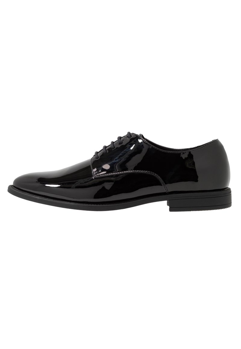 Chaussure de ville pour homme en cuir verni noir avec fermeture à lacets et talon bas empilé, présentée en profil latéral sur fond blanc.