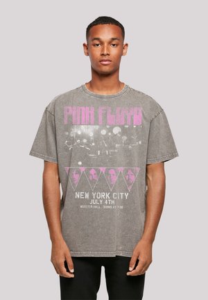 Graues, übergroßes T-Shirt mit einem verblassten Grafikdruck, der "PINK FLOYD" in Pink, Veranstaltungsdetails und ein Diamantmuster mit Gesichtern zeigt.