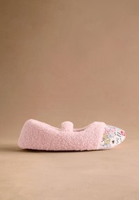Ružová papuča s chlpatou textúrou, s kvetinovým látkovým špičkovým dielom. Oblý tvar s mašličkou vpredu a mäkkou podrážkou.