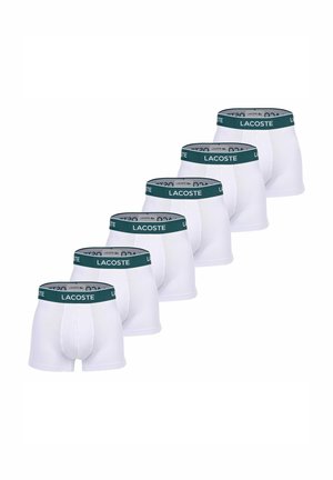 Weiße Boxershorts mit einem dunkelgrünen Bund, der das "LACOSTE"-Logo trägt. Sechs Paare in einer Reihe ausgestellt. Dehnbare Baumwollmaterial.