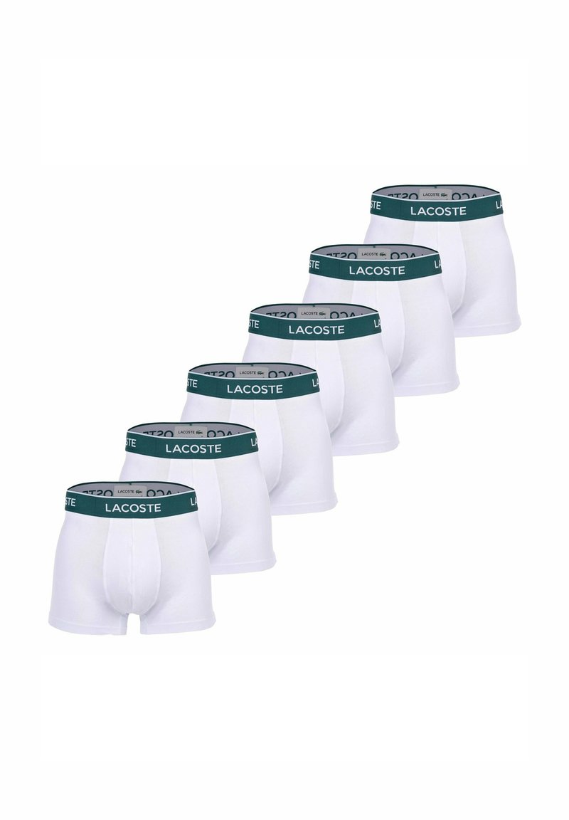 Boxers blancs avec une ceinture de couleur vert foncé arborant le logo "LACOSTE". Six paires disposées en rangée. Matière en coton extensible.