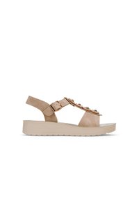 Sandale en suède beige avec semelle plate, dotée d'une fine sangle de cheville, d'un détail de boucle et d'ornements sur le devant.