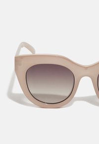 Kattöga solglasögon med en transparent blush-ram och gradient mörka linser. Slät yta med rundad form och subtila detaljer.