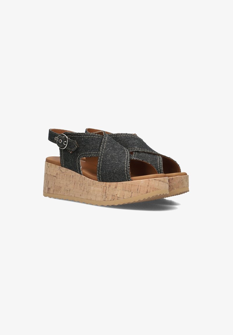 Black denim platform sandals with cork soles, open toe, cross straps, and an adjustable buckle. Textured fabric and defined stitching accents.