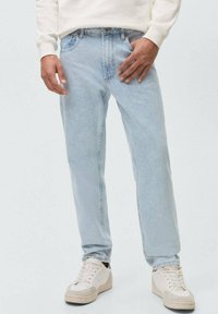 Jeans azzurri chiari con una vestibilità rilassata, realizzati in denim. Presentano passanti per la cintura, cinque tasche e una leggera scoloritura. Abbinati a sneakers bianco sporco.