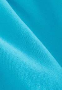 Tessuto turchese con una superficie liscia e testurizzata. Il materiale sembra leggero e flessibile, mostrando sottili variazioni di colore.