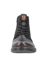 Bota de cuero marrón hasta el tobillo con paneles de ante negro, cierre de cordones en la parte delantera, cierre con cremallera y suela de goma. Cuenta con una etiqueta de cuero color tostado en la lengüeta.