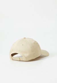 Beige baseball cap med en buet skygge, stofstruktur og justerbar rem bagpå. Ingen synlige logoer eller mønstre.