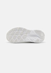 Suola di sneakers bianche in gomma textured, con un motivo di battistrada geometrico e ritagli prominenti per aderenza e flessibilità.