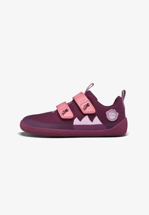 Chaussures de sport violettes avec deux bandes Velcro roses, bout arrondi, dessus en tissu texturé, semelle en caoutchouc et patch logo au talon.
