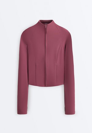 Bundá s dlouhými rukávy a zipem v barvě mauve s vysokým límcem a úzkým střihem, s prošitými švy a otvory na palce na manžetách.