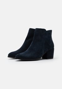 Stivaletti alla caviglia in suede blu scuro con tacco a blocco, caratterizzati da una punta rotonda e un design senza cuciture per un aspetto liscio e pulito.