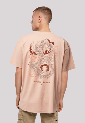 Light pink short-sleeve t-shirt featuring a large dragon graphic in shades of grey and orange, with Japanese text and cloud motifs.