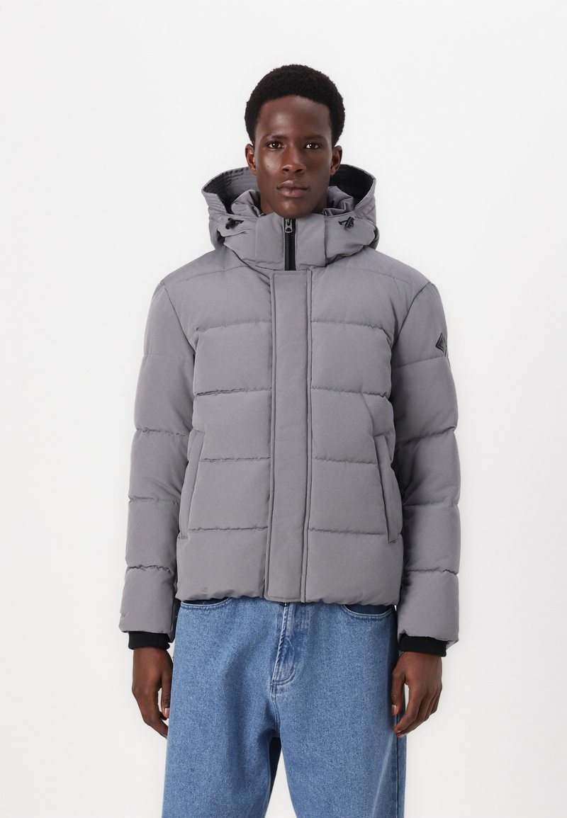 Chaqueta de plumas gris con capucha, que presenta secciones acolchadas, un cierre central con cremallera y detalles negros en los puños. Corte casual con una silueta relajada.