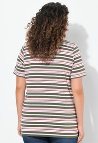 Proužkované tričko v olivové zelené barvě, s vodorovnými proužky v růžové, bílé a červené. Má krátké rukávy a volný střih.