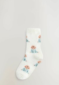 White fuzzy sock featuring a repeated pattern of a seated dog in light blue and peach tones. Soft texture and ankle-height design.