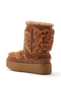 Hnedé čižmy s kožušinovým vnútrom, s textúrovaným povrchom, výškou po lýtko, s platformou a s prehnutým kožušinovým detailom na boku.