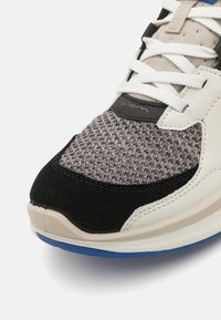 Αθλητικά παπούτσια με υφασμάτινη γκρι πλέξη, μαύρες σουέτ λεπτομέρειες, κρεμ δερμάτινες επενδύσεις, λευκά κορδόνια και μπλε καουτσούκ σόλα.