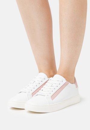 Sneakers bianchi con una striscia di accento rosa, texture in pelle liscia, punta rotonda e chiusura con lacci. Branding sottile di lato.