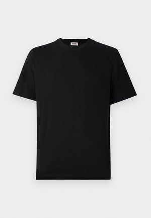 En enkel svart T-skjorte med kort erm og rund hals, lagt flat mot en hvit bakgrunn med en liten merkelapp inni kragen.