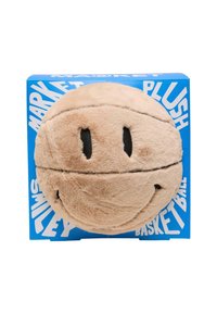 Cojín en forma de balón de baloncesto, con un exterior suave en tono marrón claro, sonrisa y ojos negros cosidos, empaquetado en una caja azul con texto blanco.