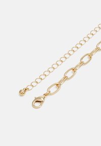 Gold-toned chain bracelet featuring oval links, a clasp closure, and a small spherical accent. Smooth texture and shiny finish.