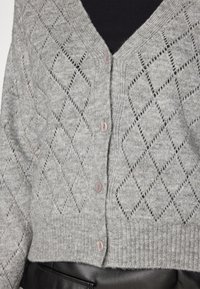 Szary sweter z dzianiny, ozdobiony wzorem diamentów, z dekoltem w serek i pięcioma jasnoróżowymi guzikami. Ribbed hem dodaje tekstury i struktury.