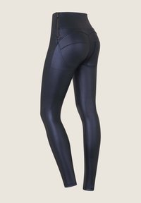 Korkeavyötäröiset, tummansiniset legginsit, jotka on valmistettu kiiltävästä kankaasta. Niissä on sivuzipperi ja ommelkorostukset, tiukka nilkka sekä strateginen paneelointi.