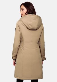 Long beige outdoor coat with a hood, featuring a textured fabric, fitted silhouette, and subtle stitching details. Black accents on sleeves.