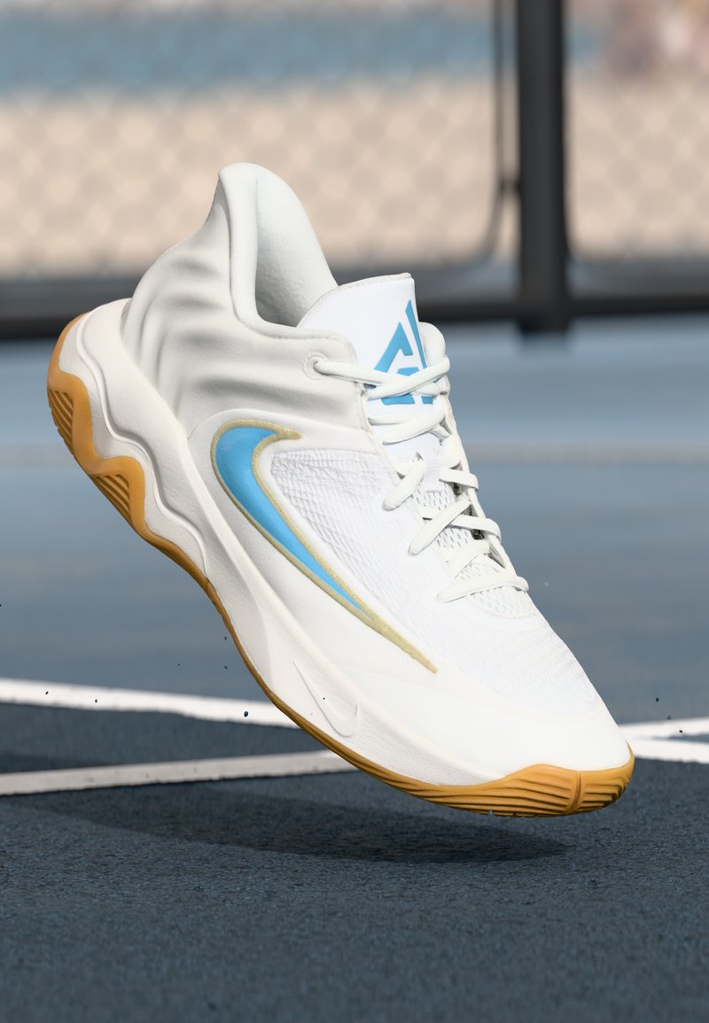 Witte sportieve schoen met gestructureerde stof, lichtblauwe accenten en een gum zool. Heeft een rond ontwerp en vetersluiting.