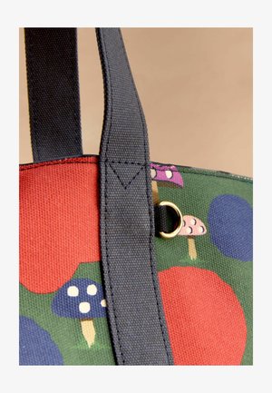 Kanga kootud kotid mustade käepidemetega, millel on värvikad seente ja abstraktsete kujundite mustrid rohelisel ja punasel kangal.