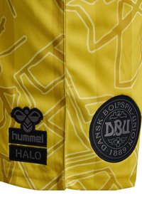 Gula idrottsshorts med vitt abstrakt mönster, med svarta "hummel"- och "HALO"-logotyper, samt ett runt DBU-emblem på sidan.