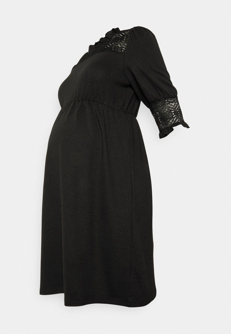 Vestido de maternidade preto com mangas curtas, decote franzido e pormenores em renda. Design fluído concebido para a silhueta de uma mulher grávida.
