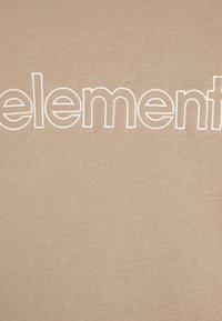 Béžový bavlnený materiál s veľkým bielym vyšitým nápisom "element." Povrch je hladký s jemne textúrovanou väzbou.