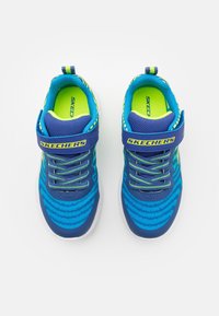 Sneakers atletici blu con una tomaia testurizzata, accenti in neon verde a contrasto, lacci elastici e una fascetta in velcro. Logo Skechers sulla fascetta.