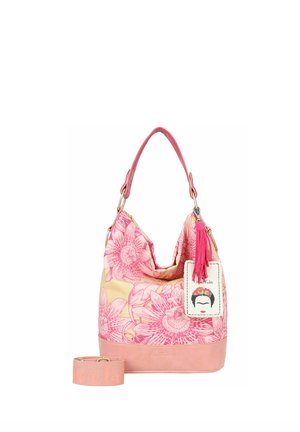 Sac à main floral rose et beige avec une poignée rose, une bandoulière amovible, un pompon et une étiquette présentant un visage stylisé avec un bandeau floral.
